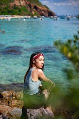 Portrait of sexy slim woman sitting on rock with beautiful seascape background, Woman sitting on seaside