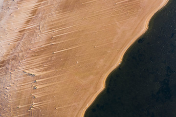 Top down view of sandy coastline, unreal view like surface of other planet.