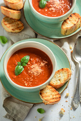 Delicious and creamy tomato soup with basil and toasts
