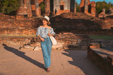 Fototapeta premium Tourist girl a portrait of fashion by pattern dot dress and jeans with sunglasses in Historic site at Ayutthaya Thailand