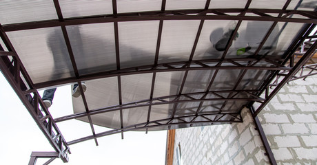 Obraz premium A worker mounts a metal canopy