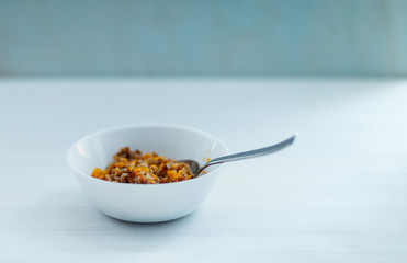 buckwheat, cooked with pumpkin, in a white Cup on a light background, shot by the light from the window