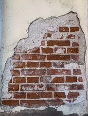 Full frame background weathered old brick wall with damaged covering after demolition works
