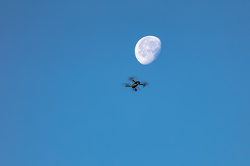 quadrocopter in the sky against the moon