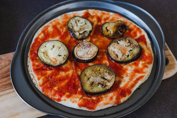 pizza base with tomato sauce and aubergine before going in the oven