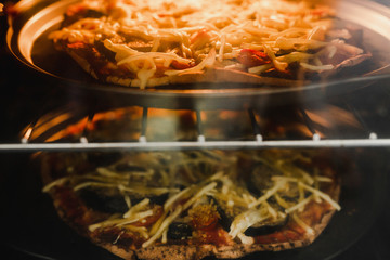 vegetables pizzas with vegan cheddar topping in the oven