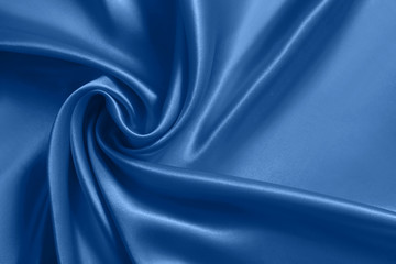 Close up of ripplesin shape of rose flower in blue silk fabric. Satin textile background. - 308009073