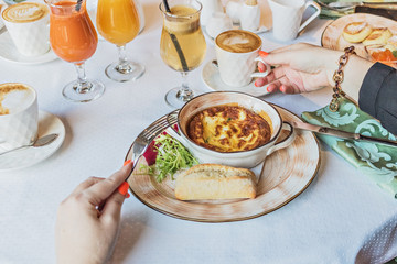 Baked omelet for breakfast. Girl's hands with appliances at the table.