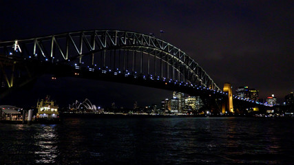Obraz na płótnie Canvas Sydney harbour bridge and city with docked ferry at night