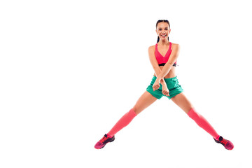 Cheerful young female jumping and dancing zumba on white background.