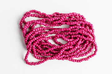 Vivid pink magenta colored plastic beads isolated on white, ready to be used for handmade objects and projects, photographed with selective focus