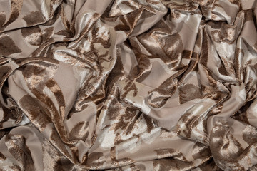 Background, texture. Close-up fragment of crumpled beige fabric.