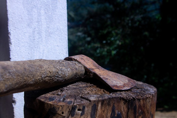Close-up on a rusty ax above a wood stump