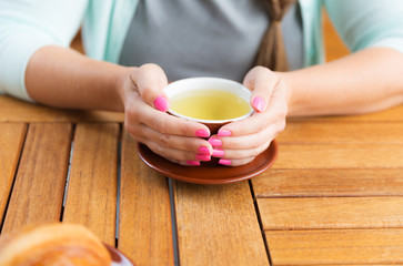Young Caucasian woman with straight hair drinking tea in a coffee shop 