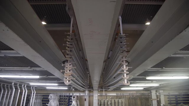 Aluminum profiles are immersed in a special solution with help girder crane. The anodizing. The process of anodizing of aluminum in the enterprise. Metal processing.