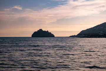 Naklejka na ściany i meble Phlegraean Islands, Ischia, Naples, Campania, Italy: silhouette of Aragonese Castle (Castello Aragonese), a medieval castle next to Ischia