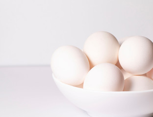 Farm white eggs in a white plate on a white background