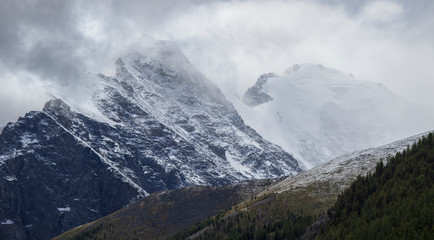 Obraz premium Top in the fog and clouds, rocky slopes. Bad weather in the mountains, morning view.