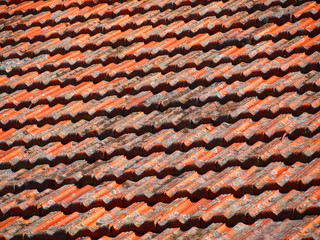 Detail shot of a residential house roof with old roof tiles with mould.