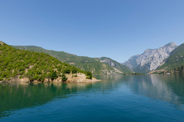 Plakat Beautiful landscape with mountains and green forests on a boat trip on the Komani lake in the dinaric alps of Albania