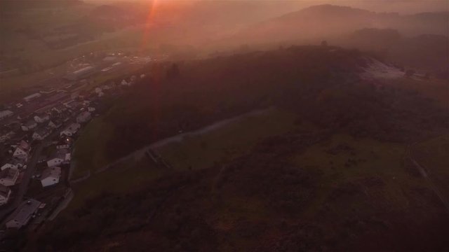Fly Cam over a valley in Germany on a fogy day in the evening