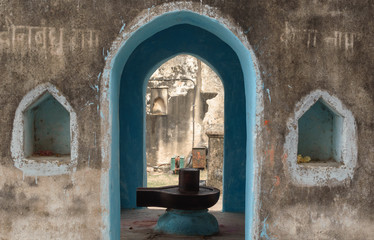 Orchha, Madhya Pradesh/India - March 14 2019: A linga inside a shrine dedicated to the Hindu God Shiva at the Raja Mahal. The walls are decorated with niches and mantras are scribbled in Sanskrit.