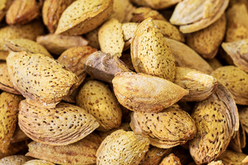 Unpeeled almonds background. Many almonds in the shell close-up, top view.