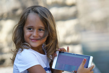 portrait of a 4 year old girl showing her cell phone