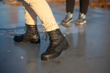 Army boots in the winter. A girl is standing on the ice.