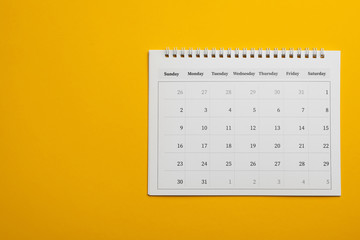 Paper calendar on yellow background, top view. Space for text