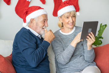 Senior couple using conference on tablet with family together at home for Christmas festival day, Retirement lifestyle concept