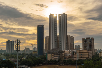Fototapeta na wymiar Mumbai, Maharashtra, India - October 2019: A cityscape with the high rises of Thakur Village and the clouds of the evening sky in the suburb of Kandivali East.