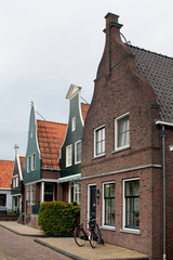 View of historical and traditional houses, bicycles in Volendam. It is a Dutch town, northeast of Amsterdam. It’s known for its colorful wooden houses and the old fishing boats.