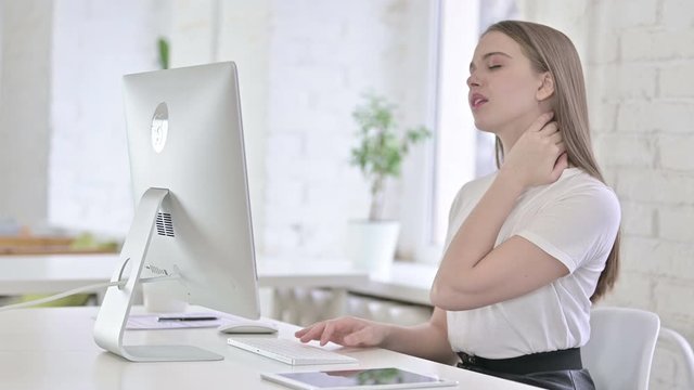 Hardworking Young Woman having Neck Pain in Office