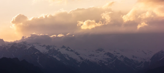 Sunlight streak through the clouds across the Shrikhand Mahadev range in the village of Sarahan in HImachal Pradesh, India. 