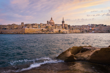 Malta. Valletta seafront at sunset with Basilica of Our Lady of Mount Carmel, viewed from Sliema.