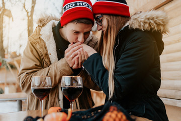 couple at the christmas market drink wine. man and woman in red hat