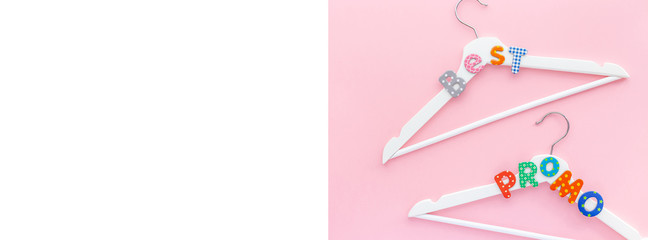 White hangers with sale text on pink background