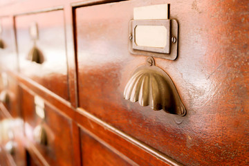 Perspective view and closeup of ancient wooden drawer in Chinese herbs shop.