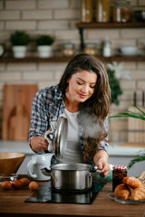 Young woman in kitchen. Beautiful woman preparing delicious food. 