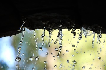 close-up of water droplets from stone arch blur background