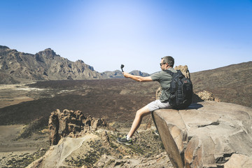 Sporty man with backpack making video with action cam to sharing online. Caucasian boy taking...