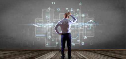 Businessman in front of a wall with User interface screens with icon, stats and data 3d rendering