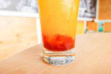 Fresh orange juice soda with strawberry syrup