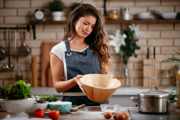 Young woman in kitchen. Beautiful woman baking. 