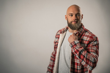 attractive man with beard and lumberjack shirt posing in studio photo on white background