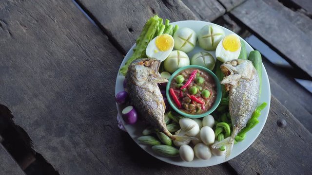 Set plate of fried mackerel with shrimp paste sauce and vegetables. Thai dish. Top view. pan shot.