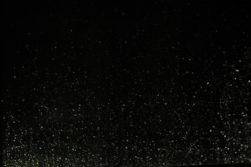 Droplets of water on a window at night with black background