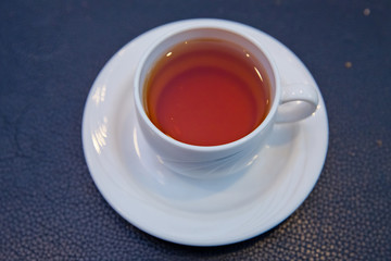 Front view . Tea cup over blue background . White Glass cup isolated on a blue background with clipping path.