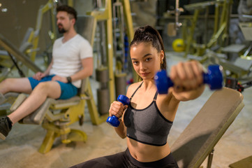 Fototapeta premium People Working Out Exercising With Dumbbells at Gym